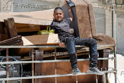 Palestinians carry their belongings after Israel's decision to demolish their homes in Nur Shams camp