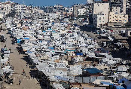 Palestinians, displaced by the Israeli military offensive, shelter in a tent camp, in Gaza City