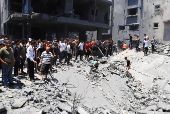 Palestinians search for casualties at the site of an Israeli strike on a house in Gaza City
