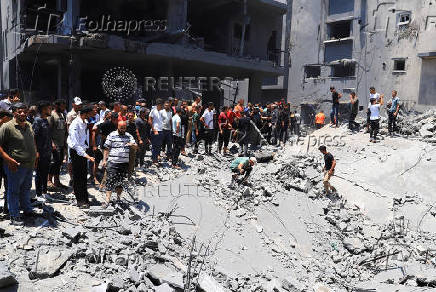 Palestinians search for casualties at the site of an Israeli strike on a house in Gaza City