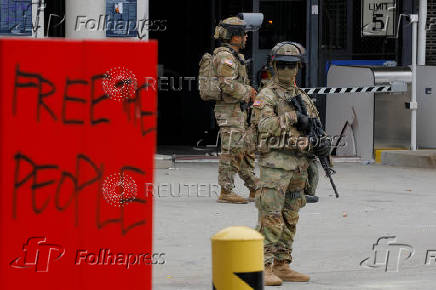 California National Guard troops stand outside the Edward R. Roybal federal building, in Los Angeles