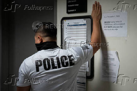A migrant is detained by federal immigration officers at U.S. immigration court