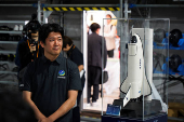 Innovative Space Carrier CEO Hatada poses with a ASCA 3 planned spaceplane model, in Yokohama