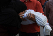 A mourner reacts near the body of a Palestinian killed in an Israeli strike, in Gaza City