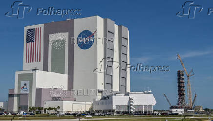 Cranes surround the Space Launch System tower next to the Vehicle Assembly Building as work continues for the Artemis II planned mission to the Moon