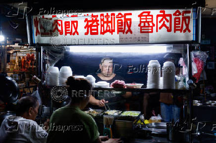 A staff member prepares food at a stall in Taipei