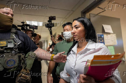 A migrant is detained by federal immigration officers at U.S. immigration court