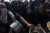 Displaced Palestinians collect donated food in Khan Yunis, southern Gaza