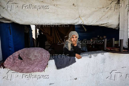 Palestinians, displaced by the Israeli military offensive, shelter in a tent camp, in Gaza City