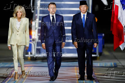 French President Emmanuel Macron and his wife, Brigitte Macron are welcomed by Indonesian Defence Minister Sjafrie Sjamsoeddin, upon their arrival at military airbase Halim Perdanakusuma in Jakarta