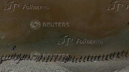 People attend a symbolic ritual named 'O Abraco' marking the World Oceans Day, at Sao Conrado beach in Rio de Janeiro