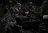 Servicemen fire a howitzer towards Russian troops at a position on front line in Donetsk region
