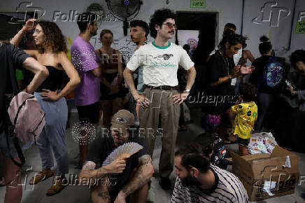 People take shelter during a siren as missiles are launched from Iran towards Israel