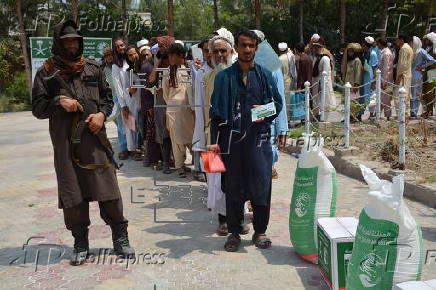Afghan families, returned from neighboring Pakistan, receive food rations distributed by the Tawheed Charity Foundation in Jalalabad