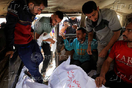 A Palestinian mourner carries the body of the stillborn baby of Palestinian woman Seham Al-Arabeed, who was killed in an a Israeli strike, according to medics, in Gaza City