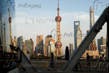 FILE PHOTO: View of financial district of Pudong is reflected on a bus passing by, in Shanghai