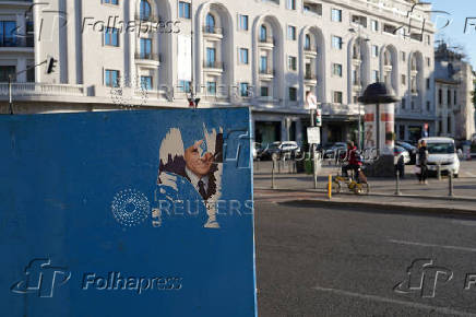 A torn electoral poster of Nicusor Dan is seen in Bucharest