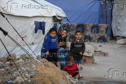 Palestinians, displaced by the Israeli military offensive, shelter in a tent camp, in Gaza City
