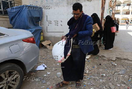 Yemenis receive food aid in Sana'a, distributed by Mona Relief agency