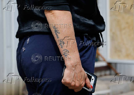 A shop owner shows the damage to her store following the shelling of a market in Donetsk