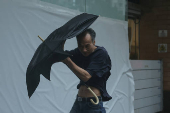 A man struggles with an umbrella while walking against strong wind, as Typhoon Wipha approaches, in Hong Kong