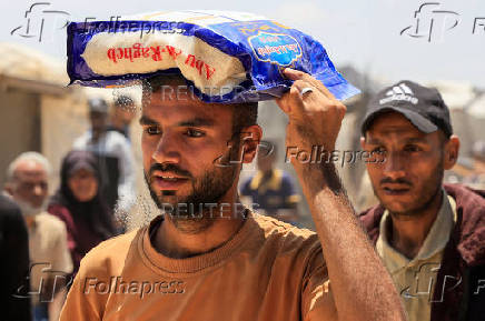 Palestinians carry aid supplies they received from the U.S.-backed Gaza Humanitarian Foundation, in Khan Younis