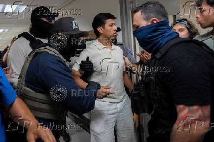 A migrant is detained by federal immigration officers at U.S. immigration court