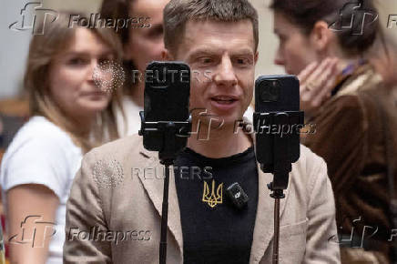 Lawmaker Oleksii Honcharenko holds smartphones as he live streams a session of Ukrainian parliament in Kyiv