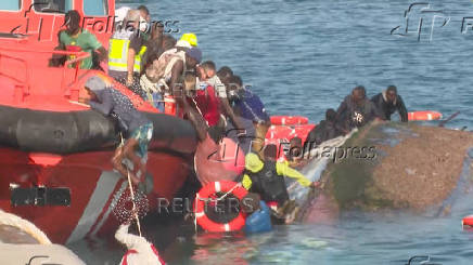 A view shows emergency services trying to rescue migrants from the water, as a migrant boat capsized, in La Restinga