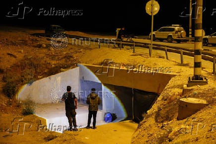 Bedouin men stand outside a tunnel under a bridge they use as a shelter in case of a rocket siren alert for a missile strike from Iran on Israel, in southern Negev