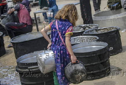 Displaced Palestinians collect donated food in Jabalia, northern Gaza