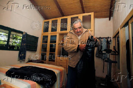 FILE PHOTO: Presidential candidate of ruling party Frente Amplio former left-wing guerrilla fighter Jose Mujica puts his clothes in his bedroom in his farm in the outskirts of  Montevideo