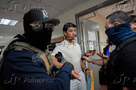 A migrant is detained by federal immigration officers at U.S. immigration court