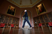 A staff member walks past a collection of rehung paintings in the renovated Long Gallery which is unveiled following a major restoration of Castle Howard, in York