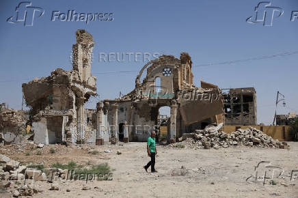 Christian citizen, George Kostantine, one of the few remaining Christians in Deir el-Zor, walks near the damaged Christ the King church in Deir el-Zor