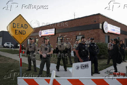 Law enforcement officers stand guard after curfew near the U.S. Customs and Immigration Enforcement facility, in Broadview