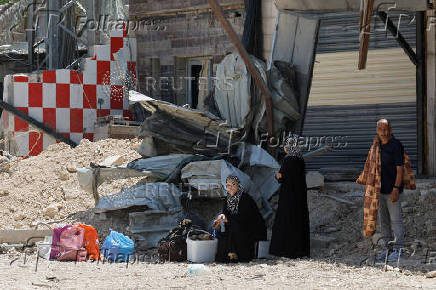 Palestinians carry their belongings after Israel's decision to demolish their homes in Nur Shams camp