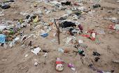 A stuffed toy lies on a beach littered with garbage in Mumbai