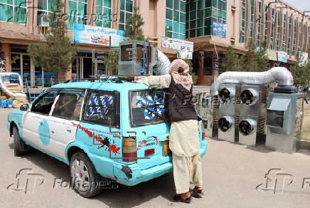 Taxi drivers install locally made air coolers to beat the heat in Kandahar