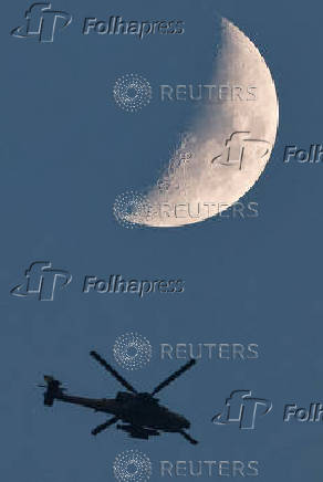 An Israeli Apache helicopter flies, near the Israel-Gaza border