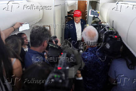 U.S. President Donald Trump speaks to members of the media on board Air Force One on the way to New Jersey