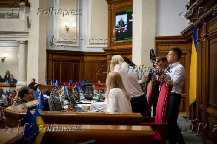 Lawmaker Oleksii Honcharenko holds smartphones as he live streams a session of Ukrainian parliament in Kyiv