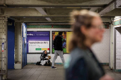A woman sits on the floor at a subway station in New York City