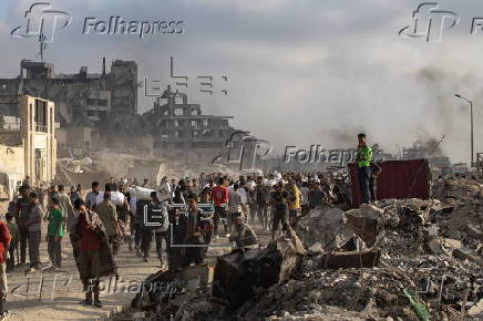 Displaced Palestinians carry relief parcels along Rashid Street, west of Gaza City