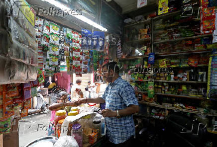 FILE PHOTO: Shivkumar Singh attends to a customer at his store in Dharavi, Mumbai