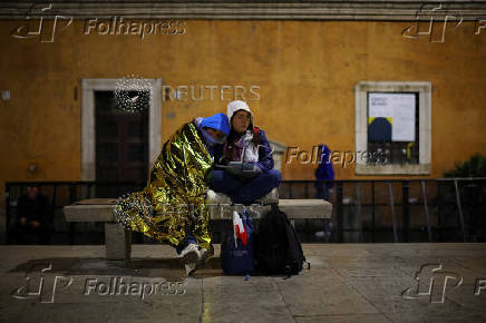 Tourists from Poland take rest while waiting to pay respects as Pope Francis lies in state, in Rome