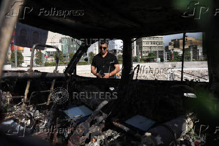 A man looks at an ambulance burned by Israeli attacks, on a street in Tehran