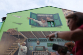 A woman passes a wall mural in the Kampong Glam district in Singapore