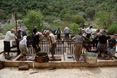 Yazidi men press olives to extract oil at the Lalish temple as part of a religious ritual in preparation for the Yazidi Red Wednesday festival, in Shekhan district near Duhok province