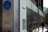 A person walks past the John Harvard blue plaque outside the John Harvard Library on Borough High Street, London